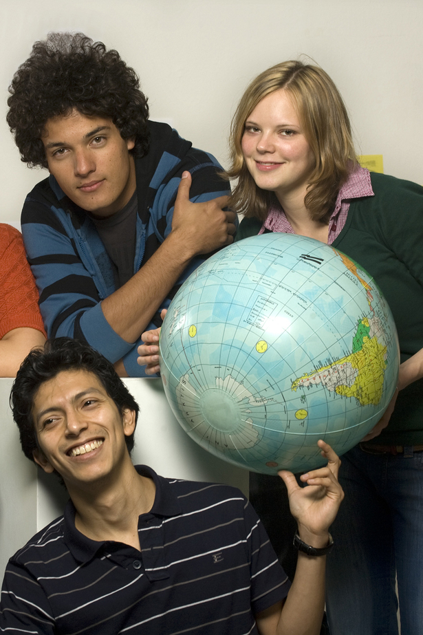 Ausländische Studierende halten eine aufblasbare Weltkugel in der Hand.