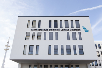 Eine Aussenfassade des Gebäudes mit dem Schriftzug Fachhochschule Bielefeld Campus Gütersloh